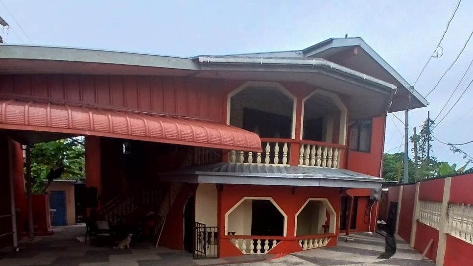 The LKJ Compassionate Hanz residence in Guapo: a two-storey home with covered verandas and a wide tiled courtyard